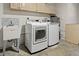 Laundry room includes a washer, dryer, utility sink, and overhead cabinets at 1582 Sandalwood Dr, Dunedin, FL 34698