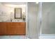 Well-lit bathroom featuring a vanity with wood cabinets, decorative mirror, and glass-enclosed shower at 1601 E Del Webb Blvd, Sun City Center, FL 33573