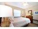 Inviting bedroom featuring soft, neutral tones, a plush bed, and natural light from the window at 1601 E Del Webb Blvd, Sun City Center, FL 33573