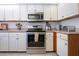 Well-lit kitchen featuring stainless steel appliances and plentiful white cabinetry at 1601 E Del Webb Blvd, Sun City Center, FL 33573