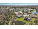 An aerial view of a home with mature trees and a pond in a lush community setting on a sunny day at 1709 Tremont Ct, Sun City Center, FL 33573