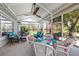 Inviting sunroom with wicker furniture, ceiling fan, and views of the manicured yard at 1709 Tremont Ct, Sun City Center, FL 33573