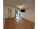 Bedroom features hardwood floors, neutral paint, and large window at 1725 Pine Ridge E Way # C, Palm Harbor, FL 34684
