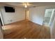 Cozy bedroom featuring hardwood floors, ceiling fan, and a TV on the wall at 1725 Pine Ridge E Way # C, Palm Harbor, FL 34684