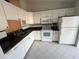 Well-equipped kitchen with white cabinets, and appliances at 1725 Pine Ridge E Way # C, Palm Harbor, FL 34684