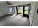 Relaxing sunroom showcasing neutral carpet and sliding glass doors to backyard at 1725 Pine Ridge E Way # C, Palm Harbor, FL 34684