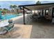 Community pool with covered lounge area, tables, chairs, and scenic views, promoting leisure and social interaction at 1725 Pine Ridge E Way # C, Palm Harbor, FL 34684