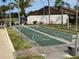 Recreational shuffleboard court surrounded by landscaped grounds for outdoor activities at 1725 Pine Ridge E Way # C, Palm Harbor, FL 34684