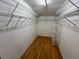 Walk-in closet with hardwood floors, wire shelving and ample storage space at 1725 Pine Ridge E Way # C, Palm Harbor, FL 34684