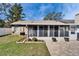 Backyard featuring a screened-in porch, manicured lawn, and a brick-paved patio area at 1728 Elk Spring Dr, Brandon, FL 33511