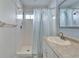 This bathroom features a shower with white tiling, blue-striped shower curtain, and updated fixtures at 1728 Elk Spring Dr, Brandon, FL 33511