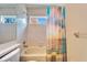 Bathroom featuring a white-tiled tub/shower combo with decorative shower curtain and modern fixtures at 1728 Elk Spring Dr, Brandon, FL 33511