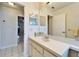 Bright bathroom with white vanity, large mirror, and tile flooring extending into the hallway at 1728 Elk Spring Dr, Brandon, FL 33511