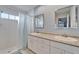 Bright bathroom featuring double sinks, white cabinets, and a tiled shower with blue-striped curtain at 1728 Elk Spring Dr, Brandon, FL 33511