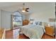 The bedroom features wood floors, ceiling fan and a window overlooking the front yard at 1728 Elk Spring Dr, Brandon, FL 33511