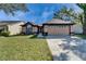 Inviting single-story home with a well-maintained lawn, a two-car garage, and attractive landscaping at 1728 Elk Spring Dr, Brandon, FL 33511