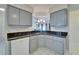 Kitchen sink area shows stylish faucet, black granite countertop, gray cabinets and modern appliances at 1728 Elk Spring Dr, Brandon, FL 33511