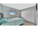 This bedroom features light blue walls, a sliding window, and a black wrought iron bed frame at 2 Adalia Ave # 803, Tampa, FL 33606