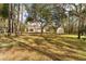 View of the expansive backyard and property featuring the home, mature trees, and an outbuilding at 22259 Skyview Cir, Brooksville, FL 34602
