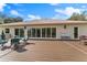 Large backyard deck with outdoor seating and lush greenery, perfect for relaxing and entertaining guests at 22259 Skyview Cir, Brooksville, FL 34602