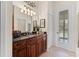 Bathroom vanity features wood cabinetry and framed mirror at 22259 Skyview Cir, Brooksville, FL 34602