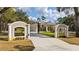 Exterior shot of the home with a circular driveway, manicured lawn and gate at 22259 Skyview Cir, Brooksville, FL 34602