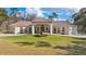 Stunning single-story home featuring manicured lawn, central fountain, a light stucco facade, and a symmetrical design at 22259 Skyview Cir, Brooksville, FL 34602