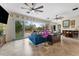 Bright living area with expansive windows, tile flooring, ceiling fans, and access to the outdoor deck at 22259 Skyview Cir, Brooksville, FL 34602
