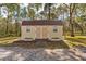 Charming backyard shed with double doors, windows, and surrounding landscaping, ideal for storage or a workshop at 22259 Skyview Cir, Brooksville, FL 34602