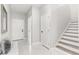 Welcoming entryway boasting white marble floors, white trim, and modern staircase at 2337 W Walnut St, Tampa, FL 33607