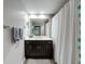 Bathroom featuring a dark vanity, a large mirror, and a shower/tub combo with a white shower curtain at 2410 W Azeele St # 220, Tampa, FL 33609
