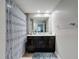Bathroom featuring a dark vanity, a large mirror, and a shower/tub combo with a shower curtain at 2410 W Azeele St # 220, Tampa, FL 33609