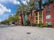 Exterior street view of the building featuring colorful accents and lush palm trees at 2410 W Azeele St # 220, Tampa, FL 33609