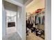 Walk-in closet with clothes and shoes, next to a bathroom with dark wood vanity at 2410 W Azeele St # 220, Tampa, FL 33609