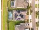 Aerial view of a home with a screened-in pool and solar panels, nestled in a neighborhood by a pond at 2641 Whittler Br, Odessa, FL 33556