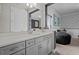 Bright bathroom featuring gray cabinetry, white countertops, and a large mirror reflecting the modern design at 2641 Whittler Br, Odessa, FL 33556