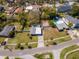An aerial view of the property showcases a well-manicured lawn, fenced yard, and its neighborhood street location at 27 Park Ave, Tarpon Springs, FL 34689