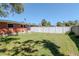 Spacious backyard with green grass, fenced, brick home, and mature shade trees at 27 Park Ave, Tarpon Springs, FL 34689