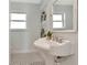 Elegant bathroom featuring a pedestal sink, black and white tiled floors, and well-lit windows at 27 Park Ave, Tarpon Springs, FL 34689
