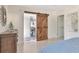 Bright bedroom featuring a decorative sunburst mirror and a rustic barn door at 27 Park Ave, Tarpon Springs, FL 34689