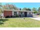 Classic single-Gathering home with brick and stucco facade, white trim, and lush green lawn at 27 Park Ave, Tarpon Springs, FL 34689