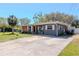Cozy single-Gathering home featuring a driveway, well-maintained lawn, and welcoming curb appeal at 27 Park Ave, Tarpon Springs, FL 34689