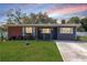 Beautiful single-Gathering home with landscaped garden, white shutters, and cozy seating on the front porch at 27 Park Ave, Tarpon Springs, FL 34689