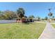 Charming brick home with a lush green front yard, mature landscaping, and a well-manicured lawn at 27 Park Ave, Tarpon Springs, FL 34689