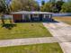 Charming single-story home with well-maintained lawn, updated front door and inviting curb appeal at 27 Park Ave, Tarpon Springs, FL 34689