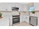 Updated kitchen featuring sleek appliances, white cabinetry and counter space at 27 Park Ave, Tarpon Springs, FL 34689