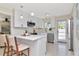 Bright kitchen featuring white cabinetry, stainless steel appliances, and modern bar seating at 27 Park Ave, Tarpon Springs, FL 34689