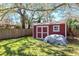 Charming backyard shed with a red door and white trim, adding character to the landscaped yard at 27 Park Ave, Tarpon Springs, FL 34689