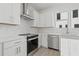 Bright kitchen with stainless steel appliances, white cabinets, and mosaic backsplash at 305 15Th N St, St Petersburg, FL 33705