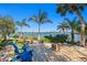 Relaxing waterfront patio with an outdoor fire pit, seating, palm trees, and beautiful water views at 3399 Maple Ne St, St Petersburg, FL 33704